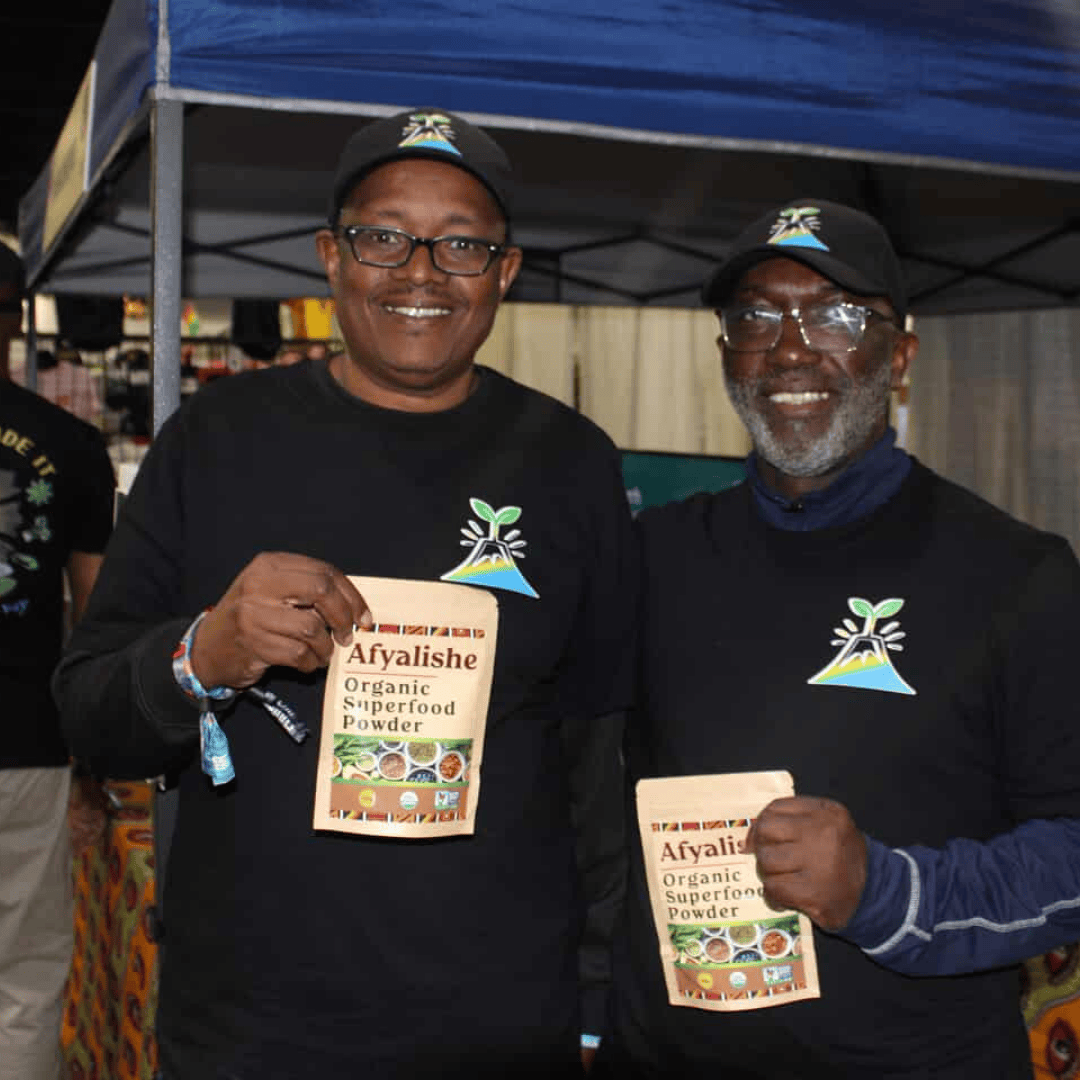 Afyalishe community photo with smiling people holding the superfood powder bag at a investing event