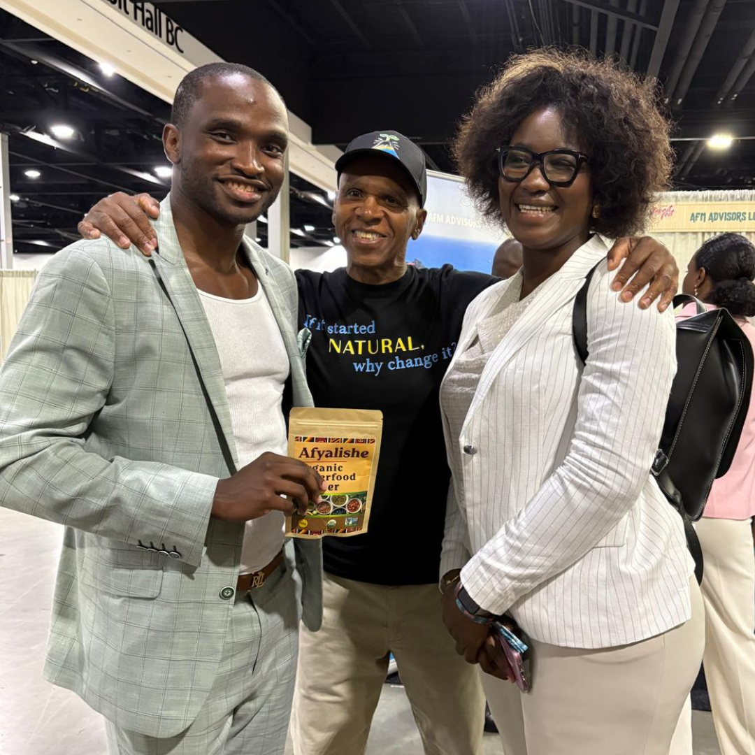 Afyalishe community photo with smiling people holding the superfood powder bag at a investing event